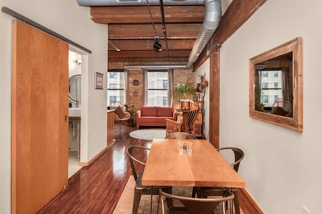 dining space with dark wood-type flooring and brick wall