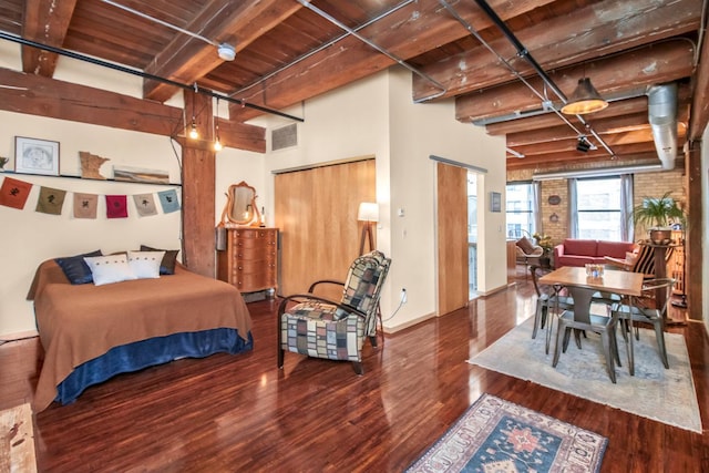 bedroom featuring dark hardwood / wood-style flooring, beamed ceiling, and wood ceiling