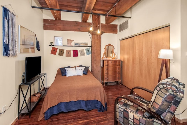 bedroom with a closet, dark wood-type flooring, wooden ceiling, and beamed ceiling