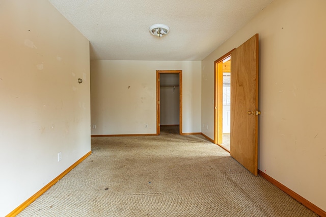 carpeted empty room with baseboards and a textured ceiling