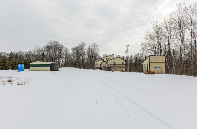 yard covered in snow featuring a storage unit and an outdoor structure