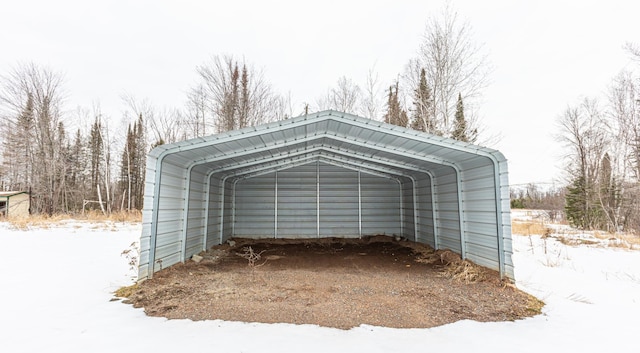 snow covered structure featuring a carport