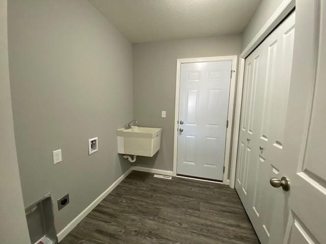 laundry room featuring sink, electric dryer hookup, and dark hardwood / wood-style flooring