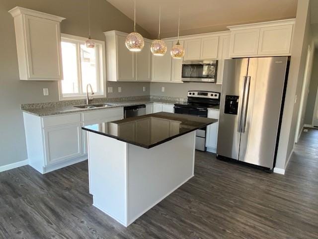 kitchen with sink, stainless steel appliances, a kitchen island, and white cabinets