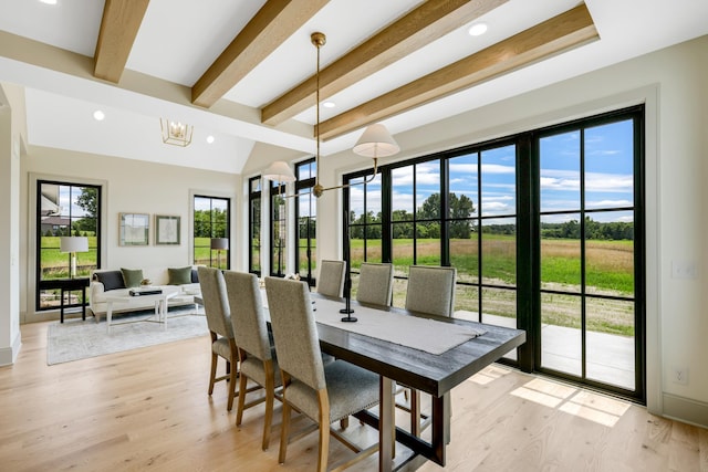 dining area featuring a wealth of natural light, beamed ceiling, and light wood-type flooring