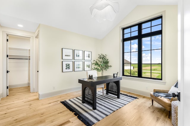 office area with light hardwood / wood-style flooring and vaulted ceiling