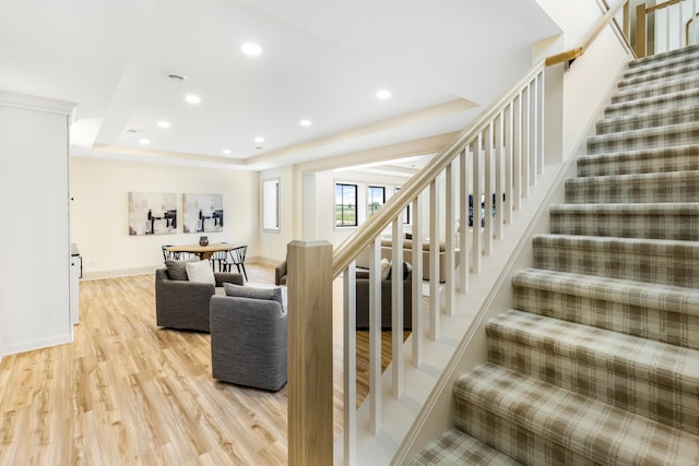 interior space with a raised ceiling and hardwood / wood-style floors