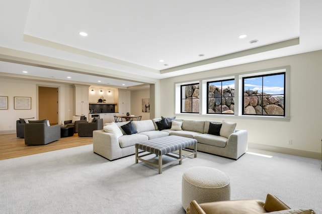 living room with light colored carpet and a tray ceiling