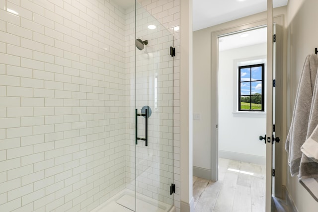 bathroom featuring a shower with door and hardwood / wood-style flooring