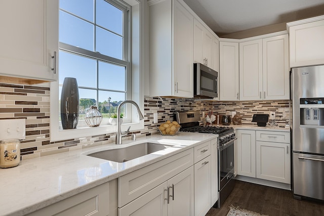 kitchen featuring dark hardwood / wood-style flooring, tasteful backsplash, white cabinets, stainless steel appliances, and sink