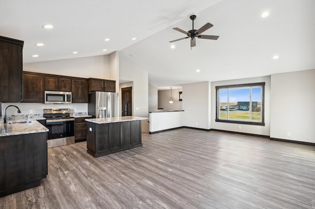 kitchen with light hardwood / wood-style floors, sink, a center island, appliances with stainless steel finishes, and high vaulted ceiling