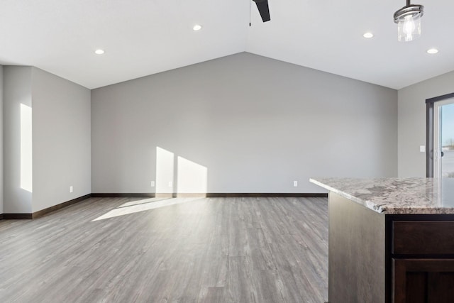 unfurnished living room featuring vaulted ceiling and light wood-type flooring