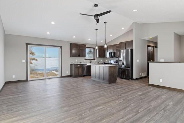 kitchen with a kitchen island, appliances with stainless steel finishes, hardwood / wood-style flooring, hanging light fixtures, and ceiling fan