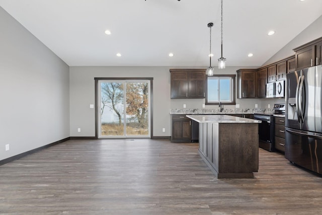 kitchen featuring dark wood-type flooring, dark brown cabinetry, a center island, hanging light fixtures, and stainless steel appliances