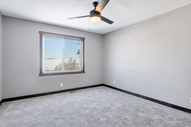 carpeted empty room with ceiling fan and a textured ceiling