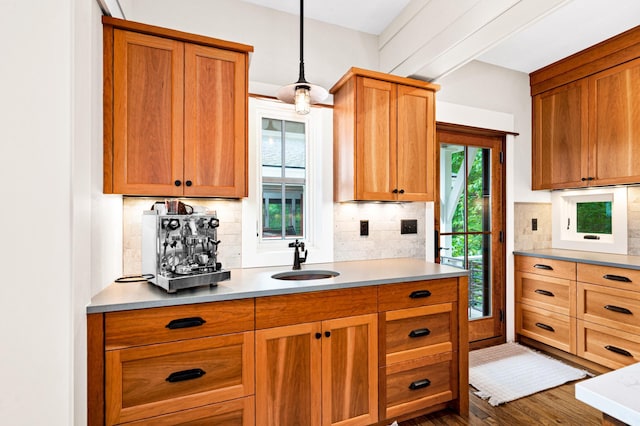 kitchen with hardwood / wood-style flooring, backsplash, sink, and hanging light fixtures