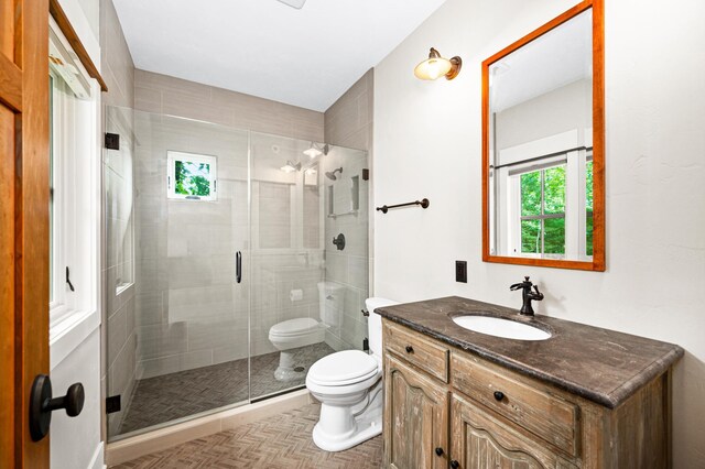 bathroom with walk in shower, toilet, and vanity