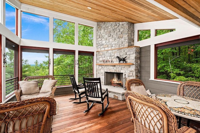 sunroom with wooden ceiling and a stone fireplace