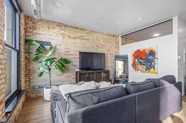 living room featuring light hardwood / wood-style floors and brick wall