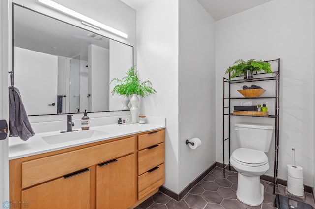 bathroom featuring tile patterned flooring, vanity, and toilet