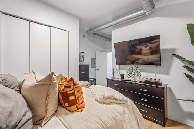 bedroom with light wood-type flooring and a closet