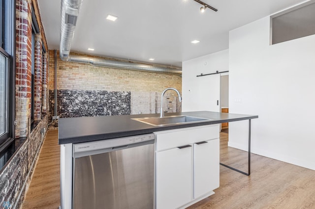 kitchen featuring white cabinets, brick wall, sink, dishwasher, and light hardwood / wood-style floors