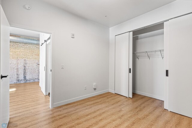 unfurnished bedroom featuring a closet and light hardwood / wood-style flooring