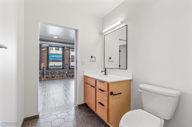 bathroom featuring toilet, vanity, and hardwood / wood-style flooring