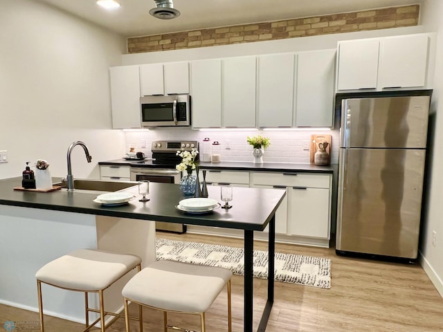 kitchen with sink, white cabinetry, and stainless steel appliances