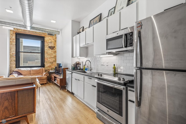 kitchen featuring white cabinets, light wood-type flooring, sink, and appliances with stainless steel finishes