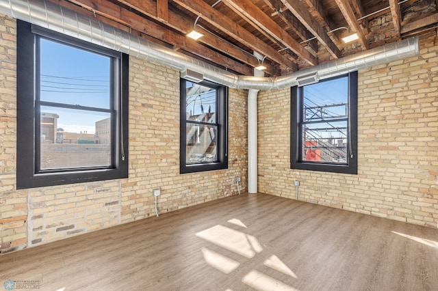 spare room featuring plenty of natural light and brick wall