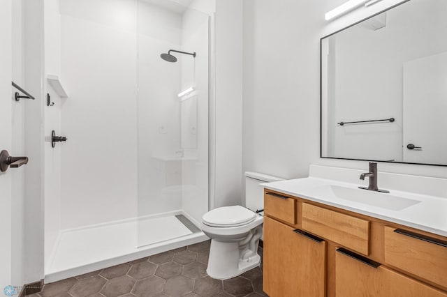 bathroom with a shower, tile patterned floors, vanity, and toilet