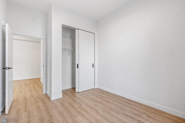 unfurnished bedroom featuring a closet and light hardwood / wood-style floors