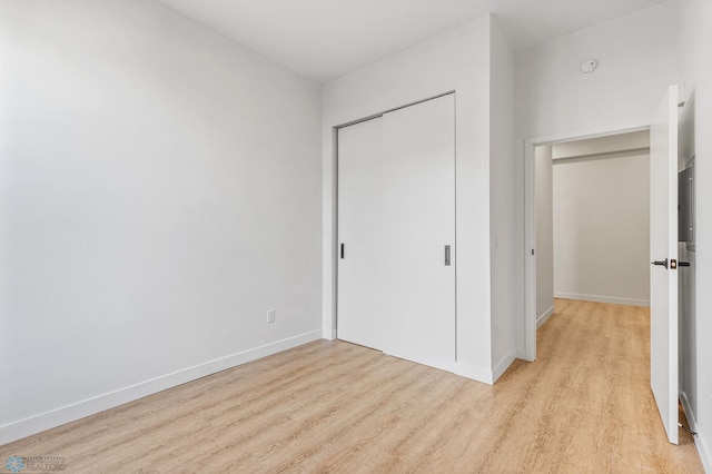 unfurnished bedroom featuring a closet and light hardwood / wood-style floors