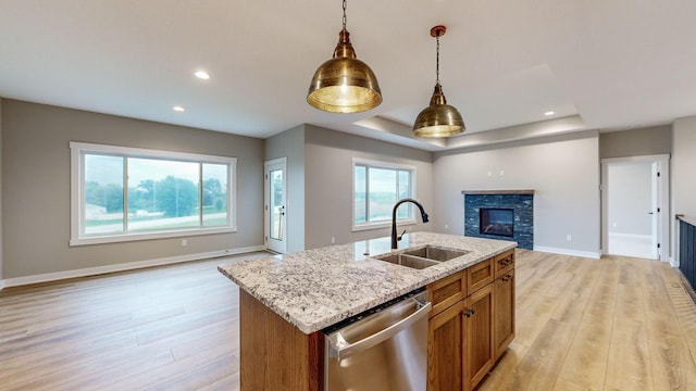 kitchen featuring an island with sink, light hardwood / wood-style floors, sink, and dishwasher