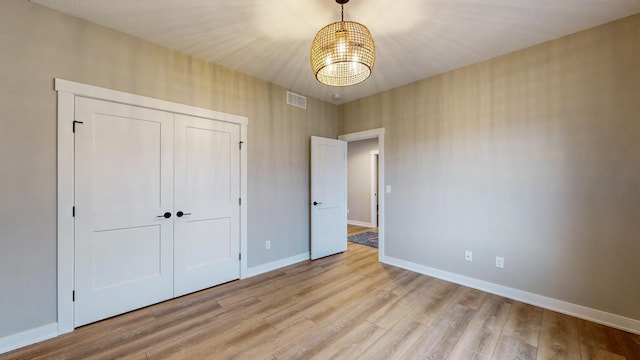 unfurnished bedroom featuring a closet and light hardwood / wood-style floors