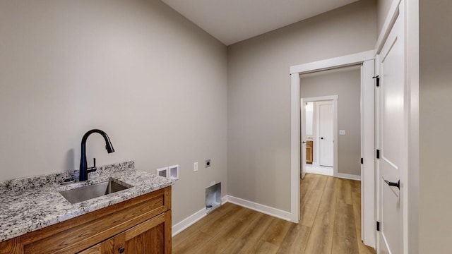 washroom with hookup for a washing machine, sink, light wood-type flooring, and electric dryer hookup