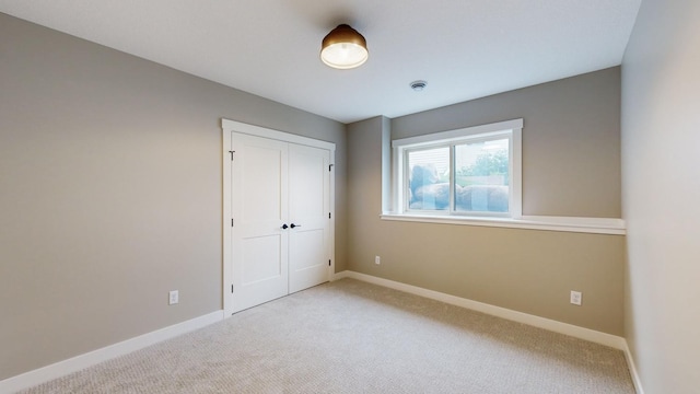 unfurnished bedroom with carpet floors and a closet