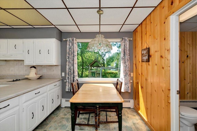 dining space featuring baseboard heating and a drop ceiling