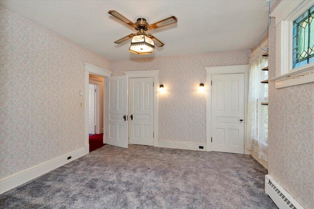 unfurnished bedroom with multiple windows, ceiling fan, baseboard heating, and carpet floors