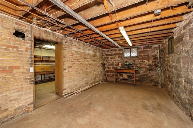 basement featuring brick wall