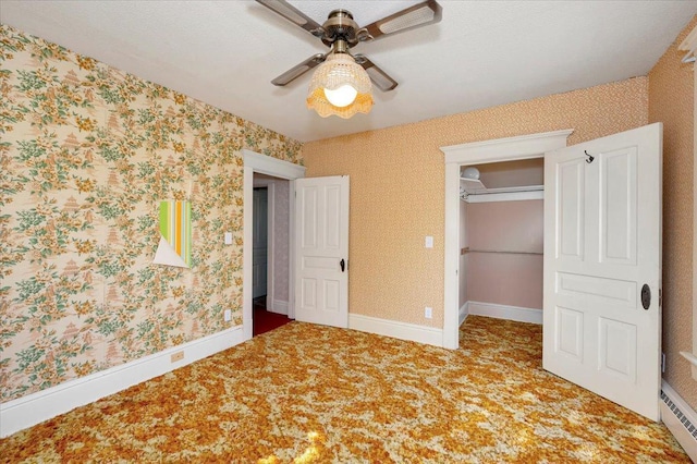 unfurnished bedroom featuring carpet flooring, a closet, ceiling fan, and baseboard heating