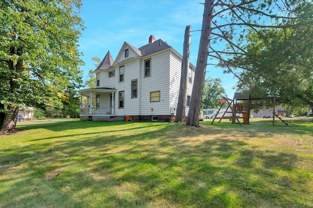 view of side of home with a playground and a yard