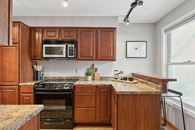 kitchen with black range with electric stovetop, a textured ceiling, and rail lighting