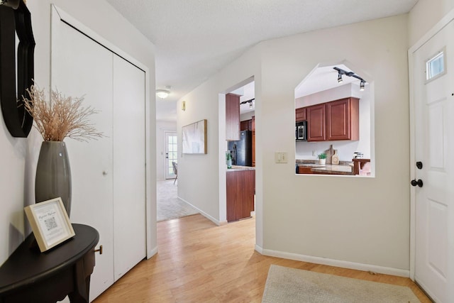 entryway featuring light wood-type flooring and a textured ceiling