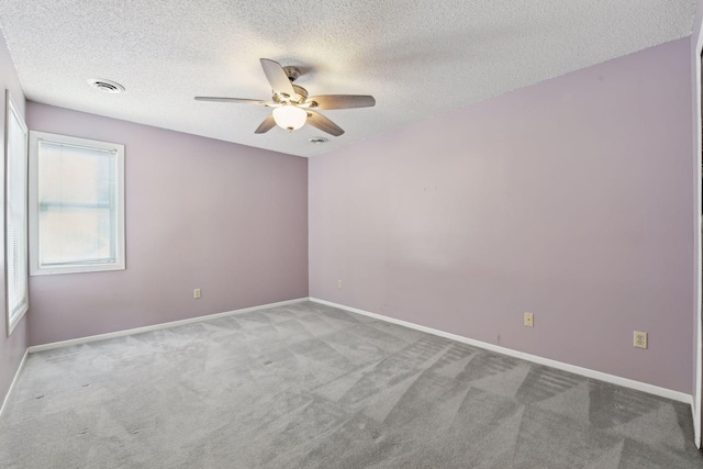 unfurnished room with ceiling fan, a textured ceiling, and carpet flooring