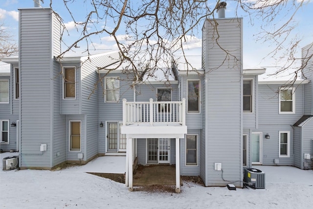 snow covered house with a balcony and central air condition unit