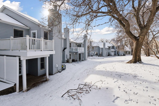 yard covered in snow with a balcony