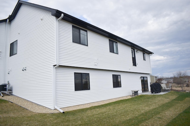 rear view of house with a yard and central air condition unit