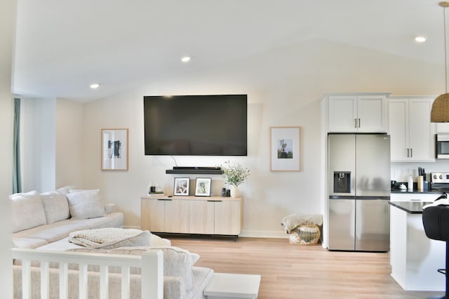 living room with vaulted ceiling and light wood-type flooring